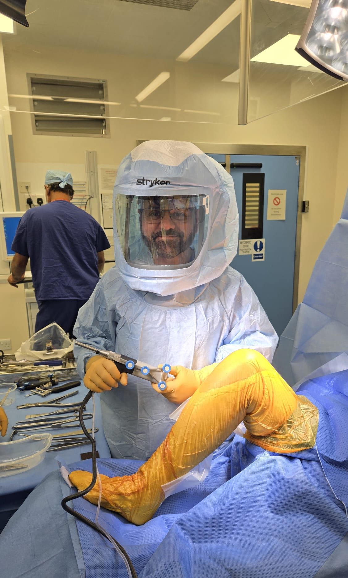 Mr Shakir Hussain in theatre with the CORI handheld robotic instrument, preparing to begin robotic knee replacement in Birmingham
